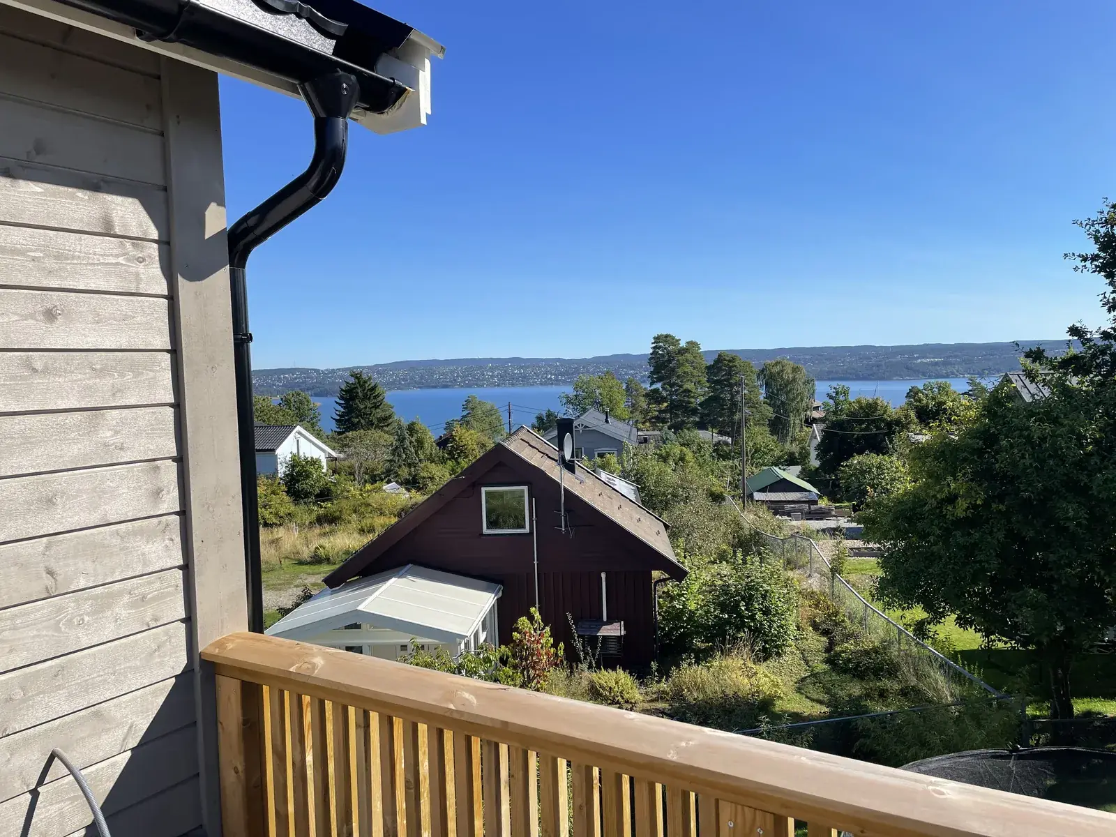 Terrasse i tre med nytt rekkverk og utsikt over fjorden, bygget av tømrer på Nesodden